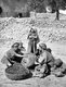 Palestine: Palestinian women with their children using a massive rock roller to crush olives for olive oil, c. 1915