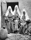 Palestine: Three Palestinian women in traditional garb together with their children. Vicinity of Jerusalem, c. 1915
